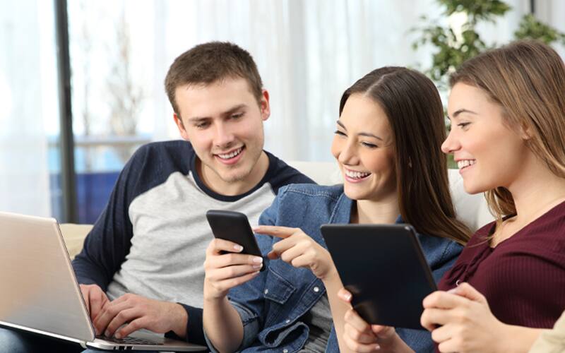 Men holding laptop women holding tab and three are watching mobile