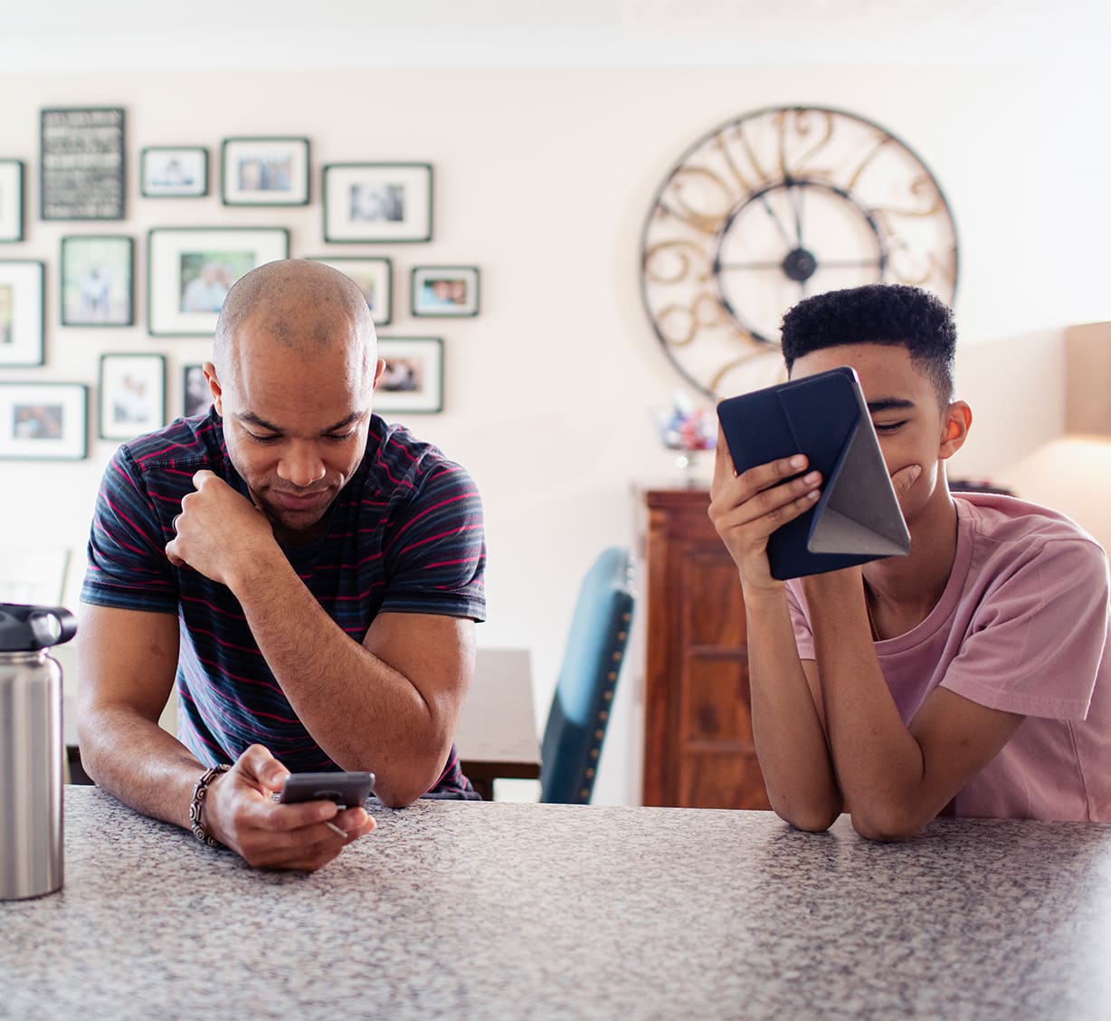 Two young children sitting on stairs viewing a tablet