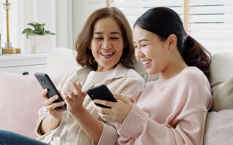 women looking at phone and smiling