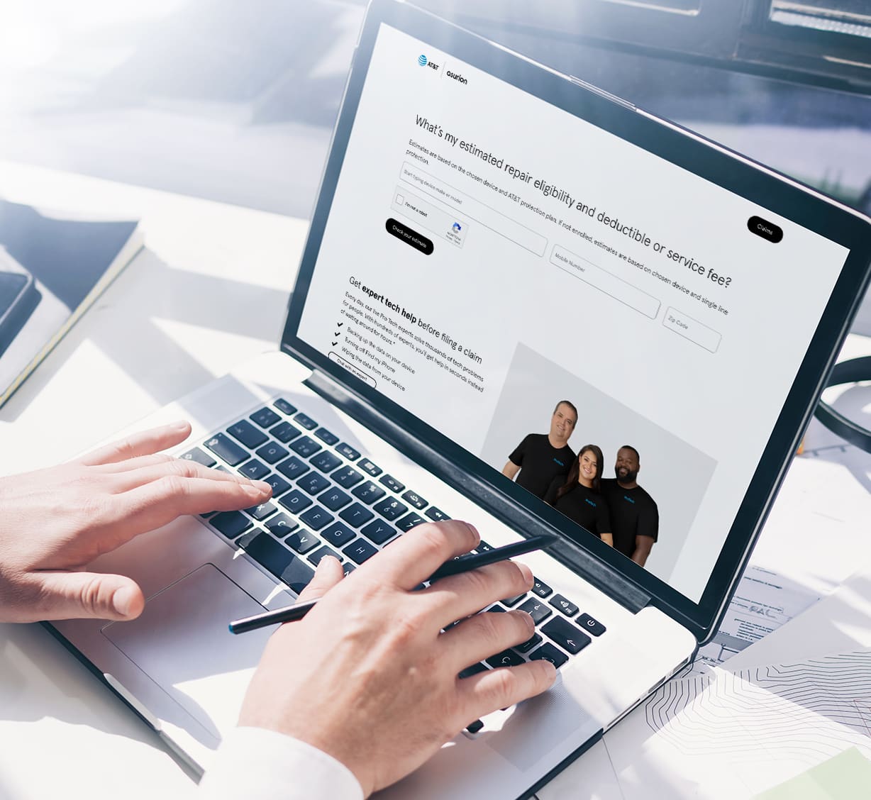 A man holding a pen and typing in laptop